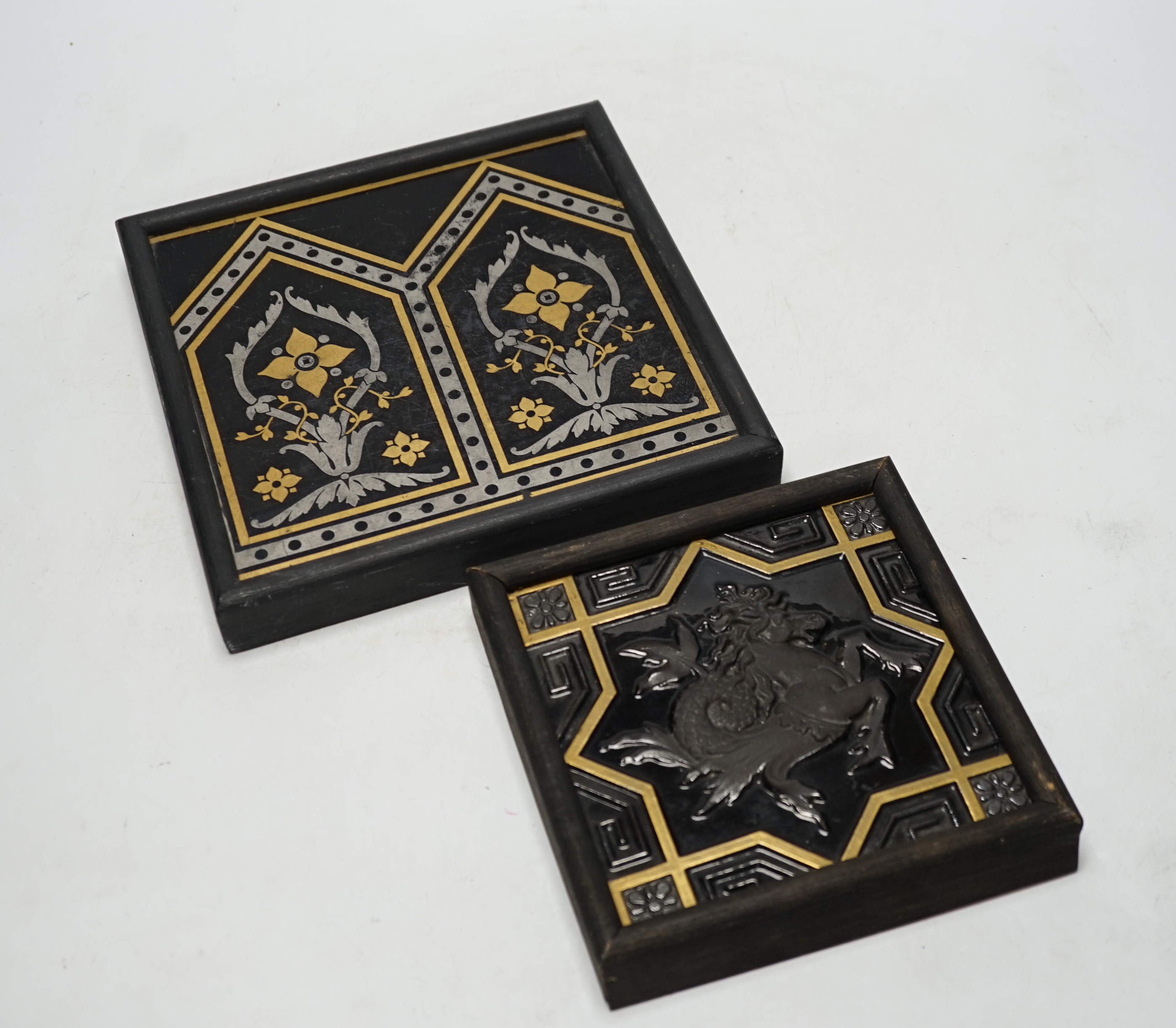 Two Minton tiles comprising one decorated in relief with a Hippocampus and one with geometric floral design, largest overall 22 x 22cm